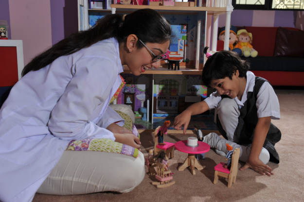 Child in creative art and sand play therapy session