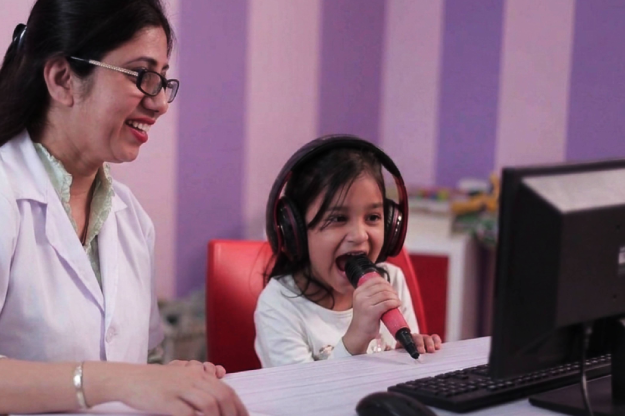 Speech pathologist working with a young child on pronunciation activities